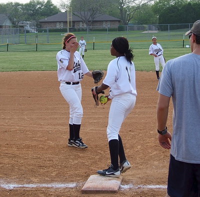 Image: Freshman teamwork: First baseman Lillie Perry(12) flips the ball back to K’Breona Davis(11) who covers first to get the out.