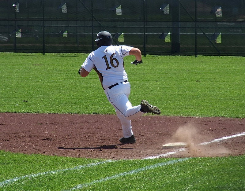 Image: Italy junior Kevin Roldan(16) makes the turn at first after pelting a double into the outfield against Dawson while mother, Flossie Gowin, cheered him from inside the concession stand.