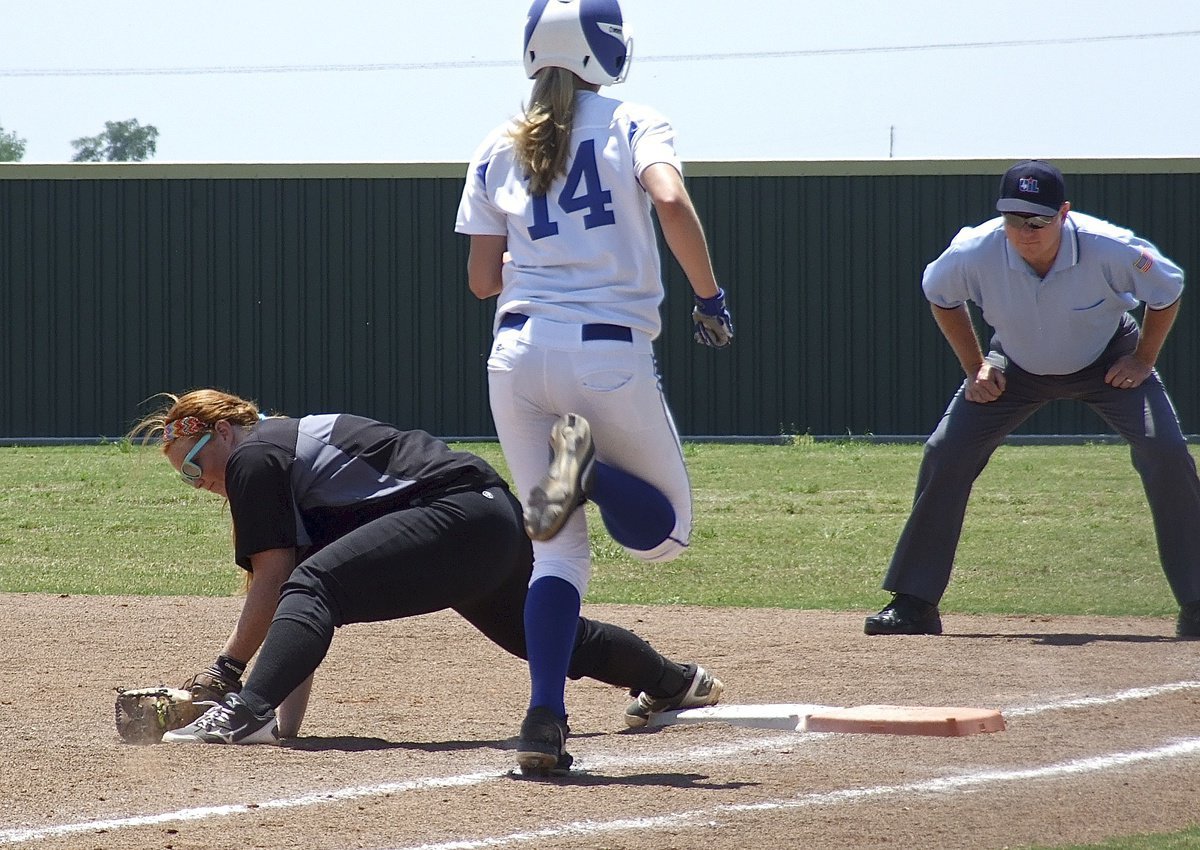 Image: First baseman Katie Byers digs the ball out of the sand in time to get a Bosqueville runner out.