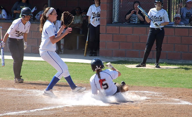 Image: Making it home to score a run for Italy is Tara Wallis(5) as teammate Bailey Eubank(1) yells for Wallis to slide.