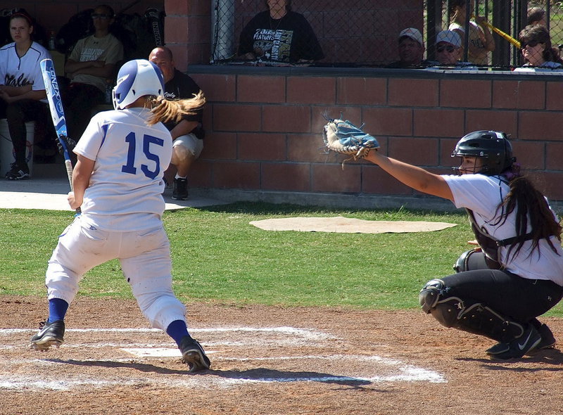Image: Catcher Alyssa Richards(9) catches a strike from pitcher Jaclynn Lewis(15) whose abilities are evident by the sand cloud surrounding the mitt of Richards.