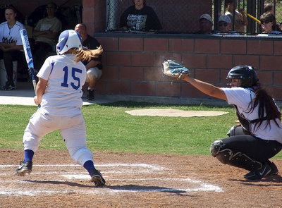 Image: Catcher Alyssa Richards(9) catches a strike from pitcher Jaclynn Lewis(15) whose abilities are evident by the sand cloud surrounding the mitt of Richards.