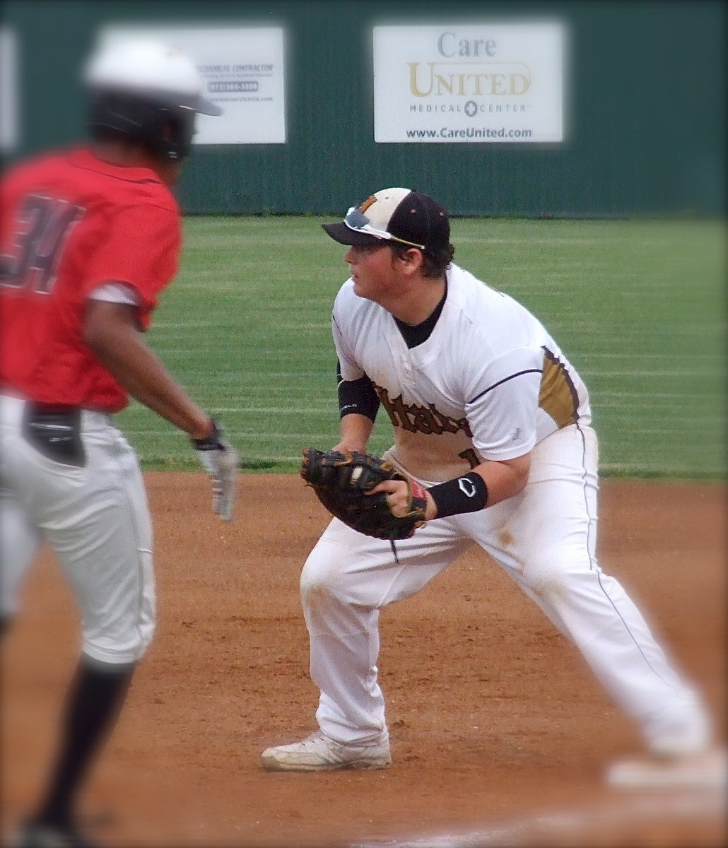 Image: First baseman John Byers(18) makes the catch to get another Trojan runner out at his base.