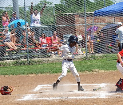 Image: Stepping on home plate to complete his home run is Italy White’s, John Hall(9), as his mother, Latoya Hall, celebrates in the stands.