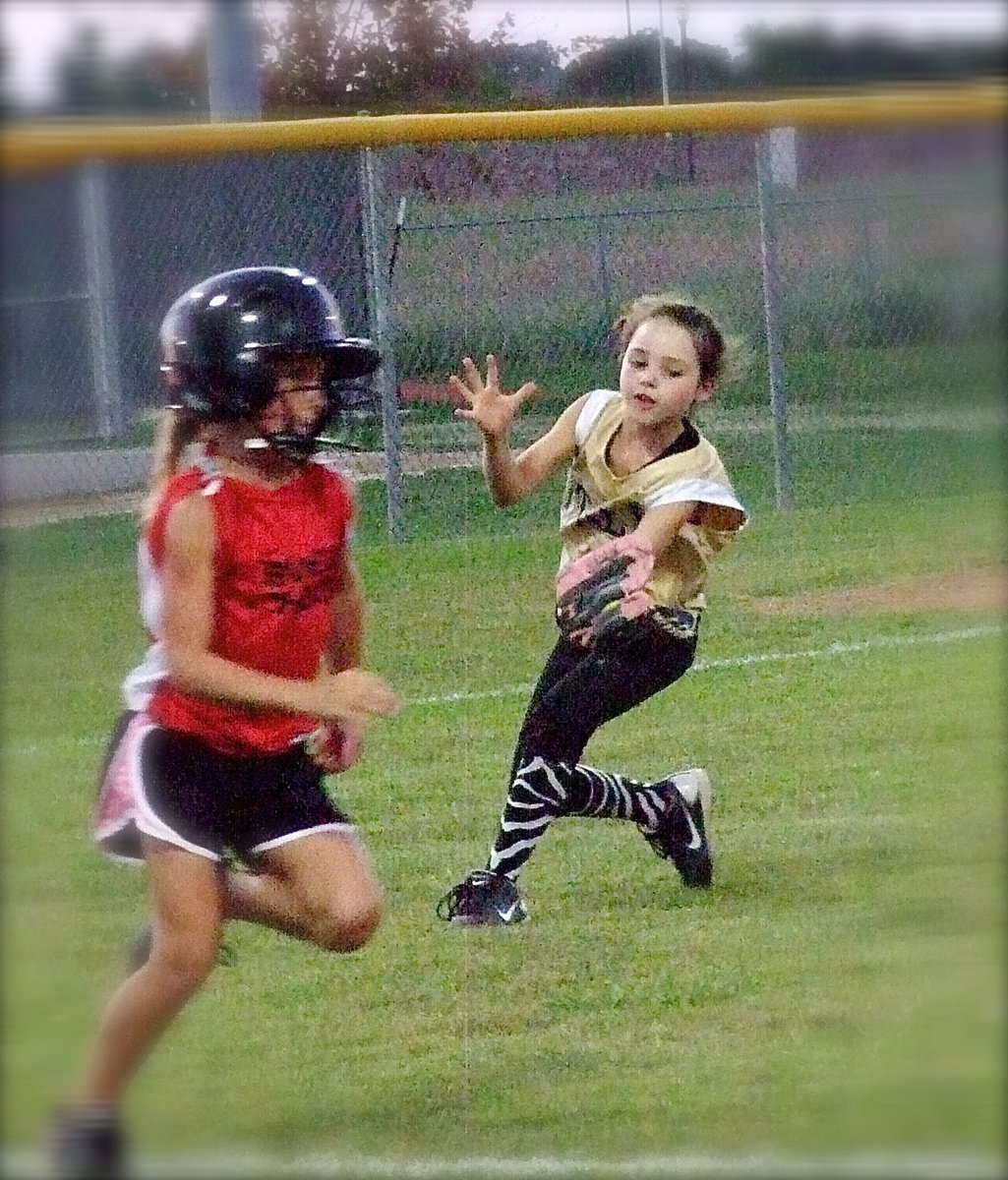 Image: Italy pitcher, Emily Janek clamps down on a mini pop-up hit back towards the mound for an out.