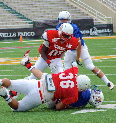 Image: Italy’s Ryheem Walker(10) helps ensure a Blue Team ball carrier is brought down.