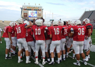 Image: Italy Gladiator, Ryheem Walker(10) joins his teammates in the huddle with the game moments from kickoff.