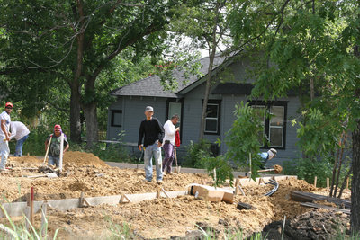 Image: Construction crew using sand to build a foundation for a new residence in Italy.
