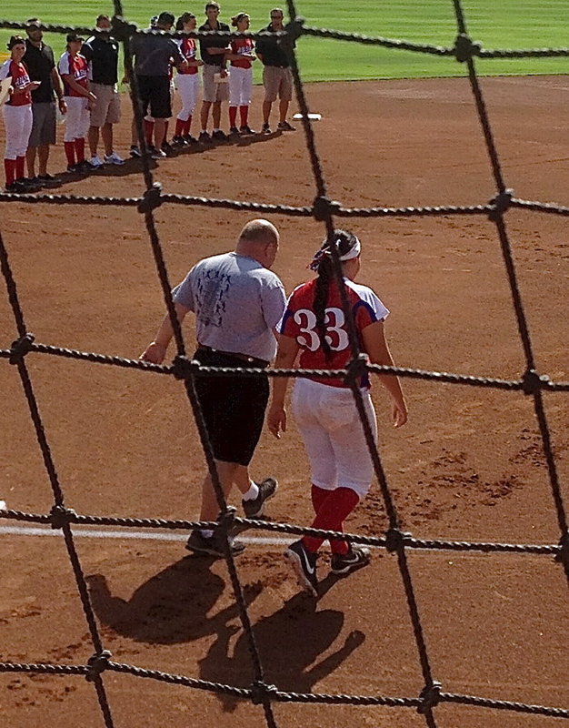 Image: Alyssa Richards(33) is escorted onto the All-Star field by her Italy High school softball coach, Wayne Rowe, who coached Richards in her senior season.