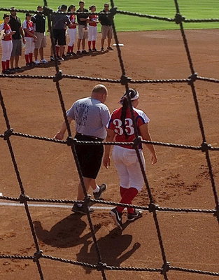 Image: Alyssa Richards(33) is escorted onto the All-Star field by her Italy High school softball coach, Wayne Rowe, who coached Richards in her senior season.