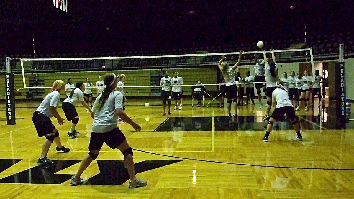 Image: Sophomore Halee Turner and senior Paige Westbrook combine for the block attempt, with Bailey Eubank backing them up, as the varsity gets challenged.