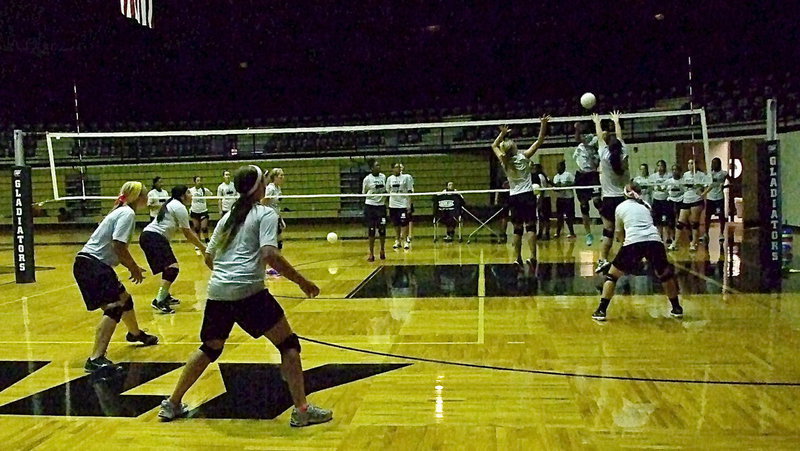 Image: Sophomore Halee Turner and senior Paige Westbrook combine for the block attempt, with Bailey Eubank backing them up, as the varsity gets challenged.