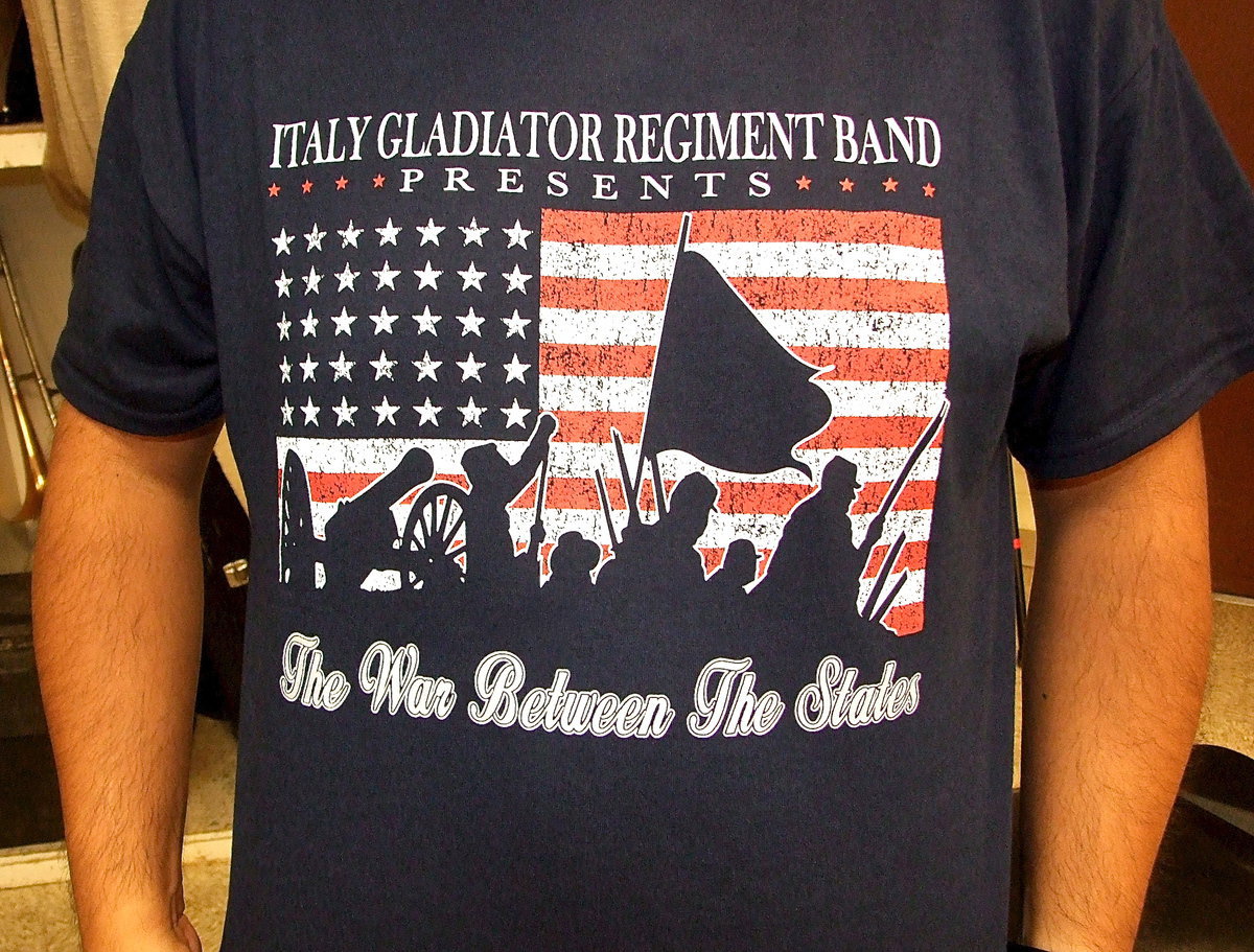 Image: Band Director Jesus Perez displays the band’s tshirt that arrived on time and promotes their concert theme entitled, “The War Between The States.”