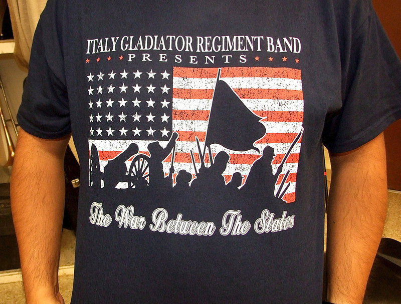 Image: Band Director Jesus Perez displays the band’s tshirt that arrived on time and promotes their concert theme entitled, “The War Between The States.”