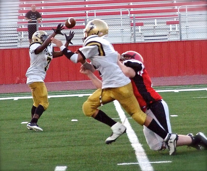 Image: Back in at quarterback, Joe Celis(2) beats the Panther rush to complete a backwards pass to teammate Johnny Norris(7).