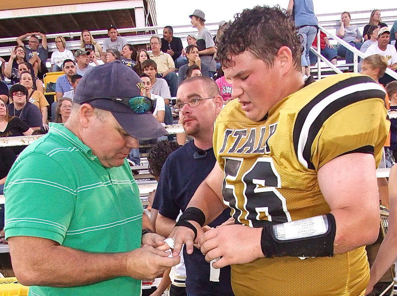 Image: Italy Firefighters Jackie Cate and Brad Chambers reset a dislocated finger for John Byers(56) who eventually returned to the middle of the Gladiator defense.