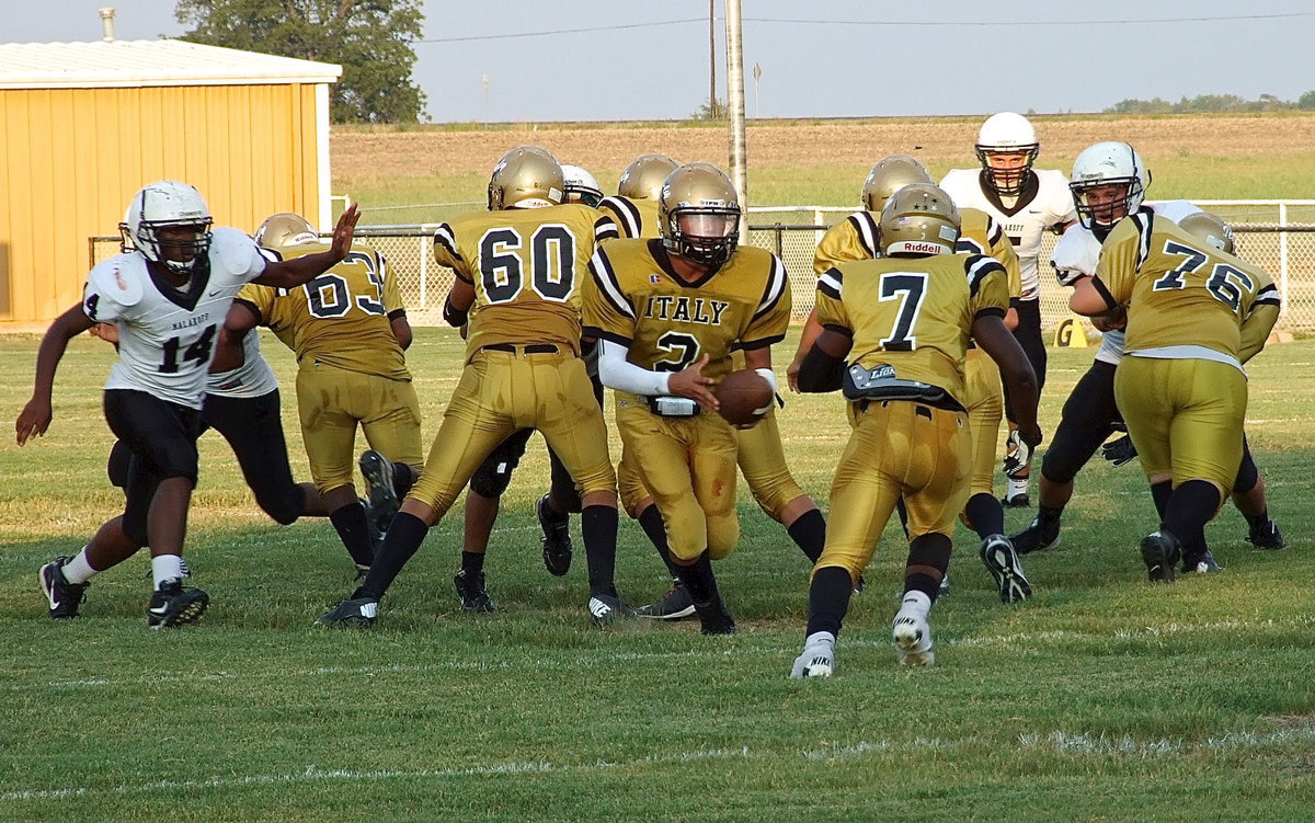 Image: Quarterback Joe Celis(2) turns to handoff to Johnny Norris(7) with Kenneth Norwood, Jr.(63), David De La Hoya(60) and Samuel Corley(76) leading the way.