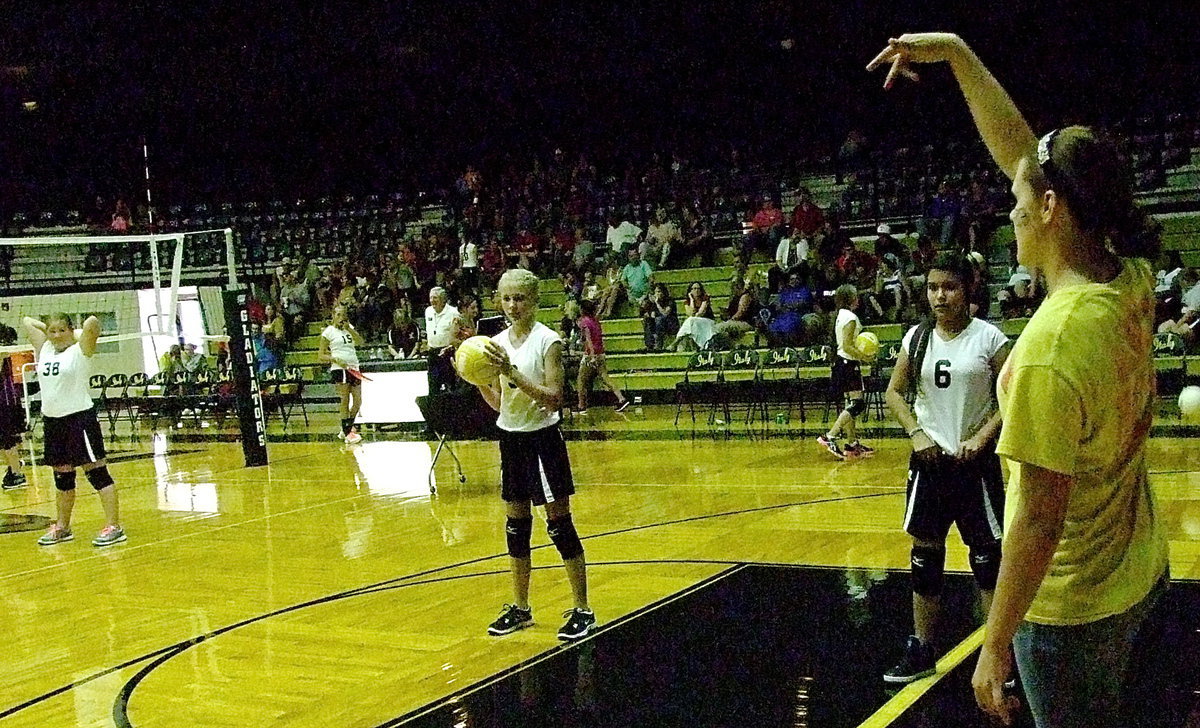 Image: Sophomore Lady Gladiator Lillie “Coach” Perry helps the Junior High girls during pre-game drills.