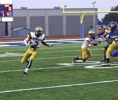 Image: Trevon Robertson(3) returns the opening kickoff for Italy with teammate Tyler Anderson trying to provide resistance.