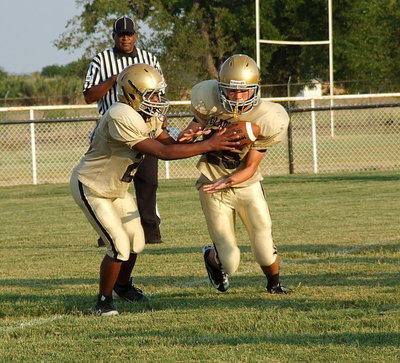 Image: Quarterback Kendrick Norwwod(20) hands off to teammate Kyle Tindol(25).
