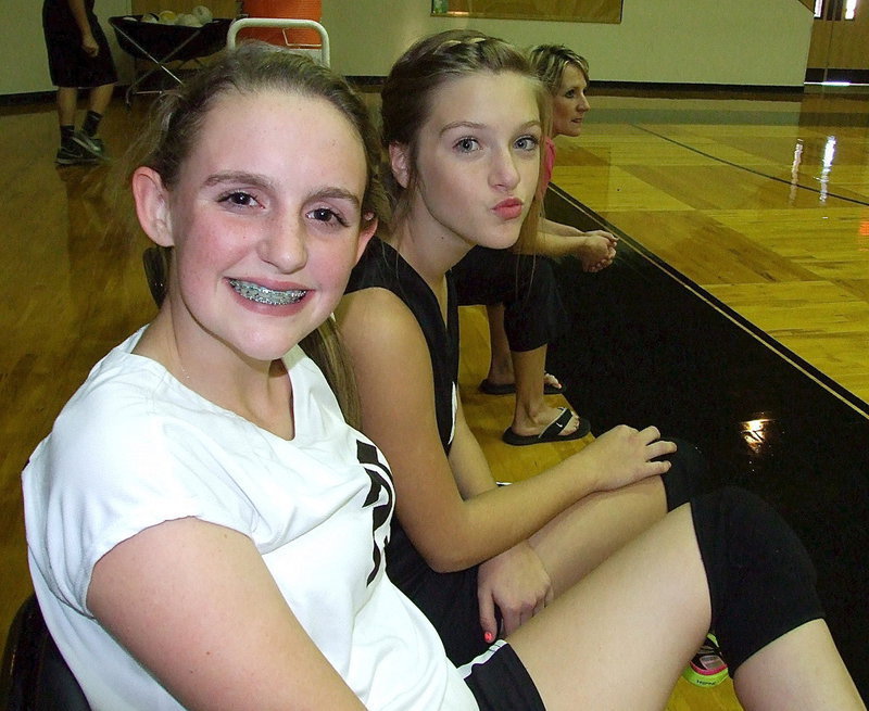 Image: Kirby Nelson(25) and Kristen Viator(4) support their teammates along with Coach Morgan Mathews.