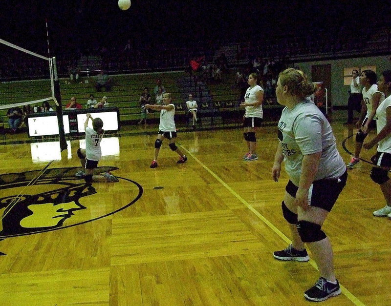 Image: Emma Martinez(7) slides under the ball on one knee to keep the volley going.