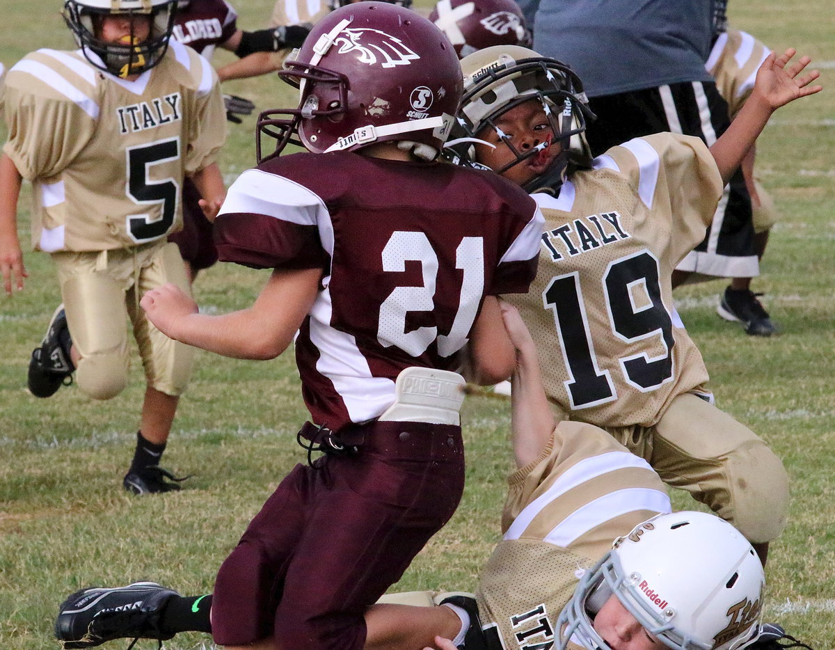 Image: Italy’s Garred Wood(7) and Cory Johnson(19) pull down an Eagle runner before he can reach the endzone.