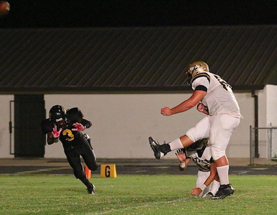 Image: Kevin Roldan(60) boots thru a point-after kick with Tyler Anderson(11) holding. Roldan made 4-of-6 P.A.T.s for the Gladiators.