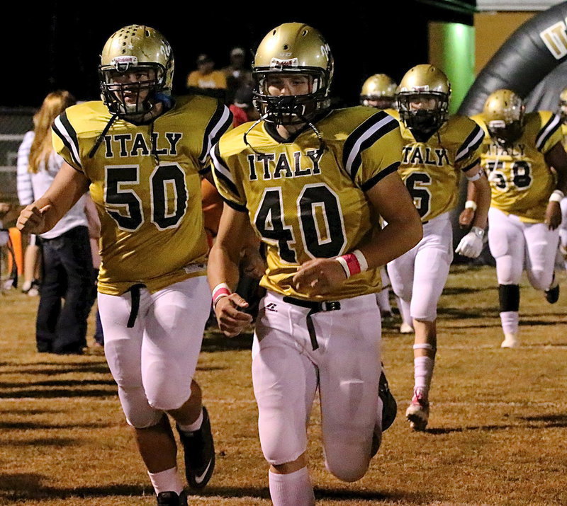 Image: Zain Byers(50), Coby Bland(40), Clayton Miller(6) and Darol Mayberry(58) charge out of the tunnel and onto the field.