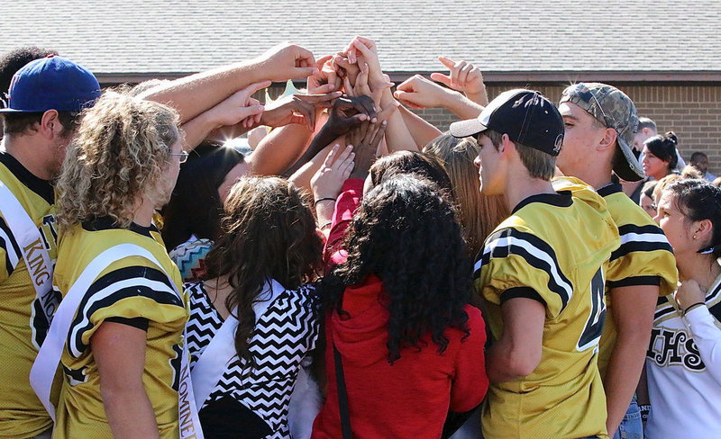 Image: Senior Gladiators Kevin Roldan, Shad Newman, Justin Wood and Cody Medrano join their classmates in the senior circle following the downtown homecoming pep rally.