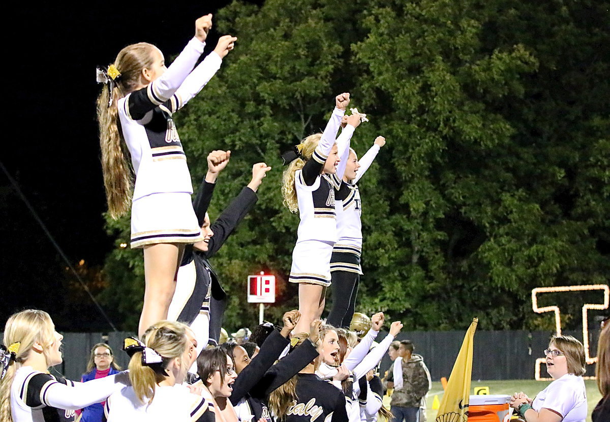 Image: Cheerleaders Karley Nelson, Taylor Boyd, Karson Holley and Britney Chambers get a lift from their fellow cheer mates.