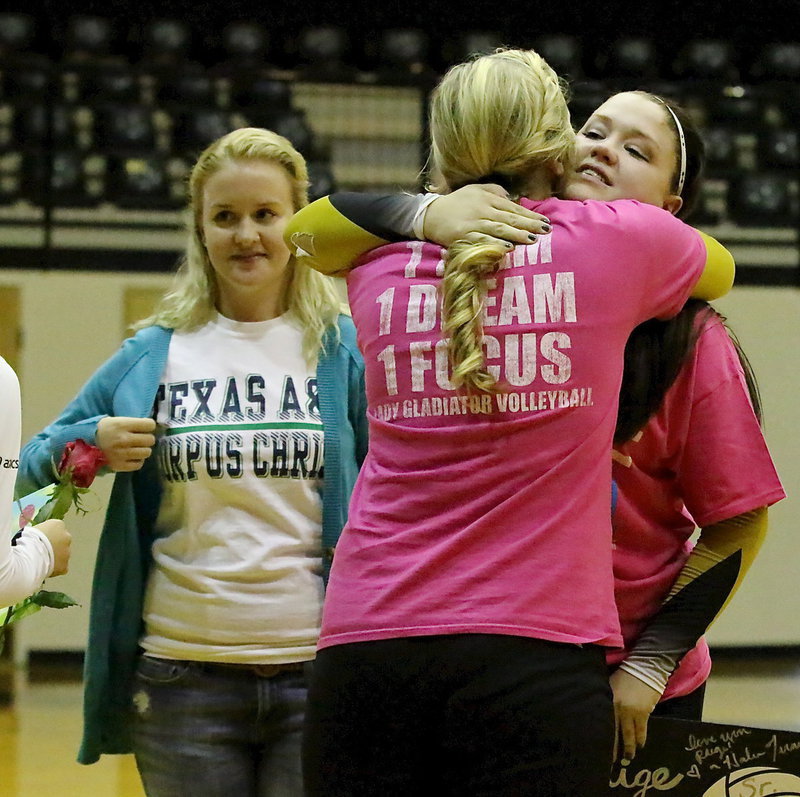 Image: Teammate, Jaclynn Lewis(13), gives senior, Paige Westbrook(11) a hug after presenting the senior with a poster collage of memories.