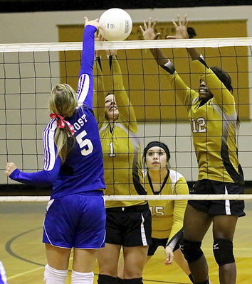 Image: Monserrat Figueroa(15) backs up Bailey Eubank(1) and Kortnei Johnson(12) who go for a block against Frost.