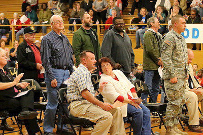 Image: Veterans begin to stand during the playing of service songs by the Gladiator Regiment Band.