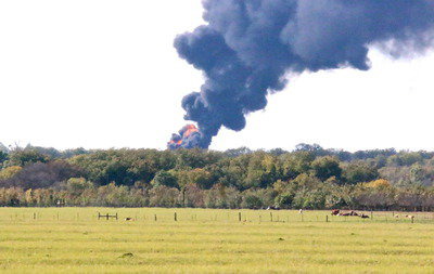 Image: Smoke and fire emerge from the tree line and cast an ominous cloud over citizens in nearby Milford and the surrounding rural area.