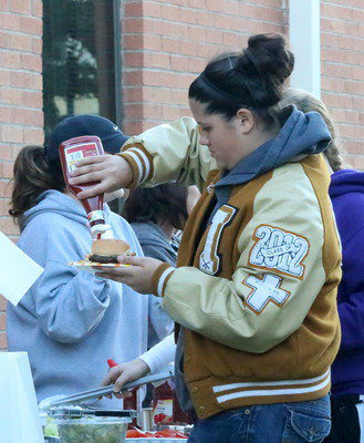 Image: Regiment band member Jenna Holden puts some ketchup on it.