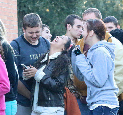 Image: Gladiator Bailey Walton and cheerleaders Ashlyn Jacinto and Paige Little share a laugh while waiting in the food line.
