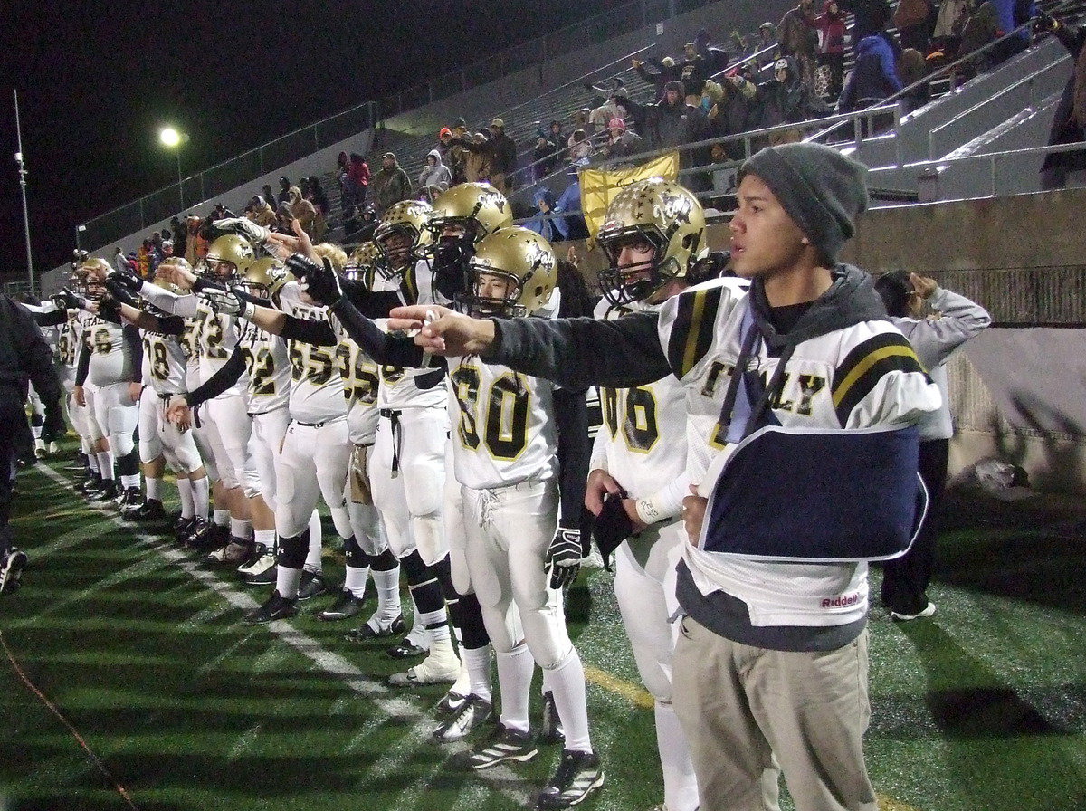 Image: Gladiators Joseph Celis(2), Kyle Fortenberry(66) and Dylan McCasland(3) join their teammates in signaling it’s time for the opening kickoff.