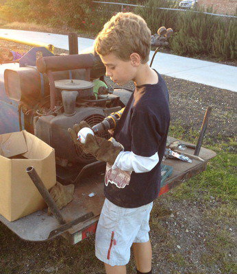 Image: Creighton Hyles drills holes thru the center of baseballs in order to pass a cable thru the core. The balls will help everyone to identify the cable wire which separates the walking trail from the parking area.