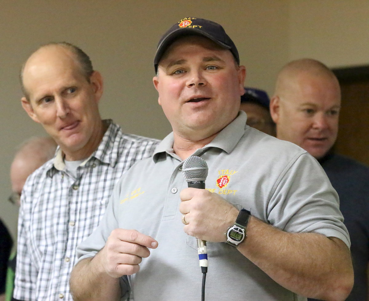 Image: We don’t need no siren, just hand Captain Jackie Cate the microphone! Cate also serves as president of the Fire District Board. Captain Cate—his title sounds like that of a superhero and, well, he just may be.