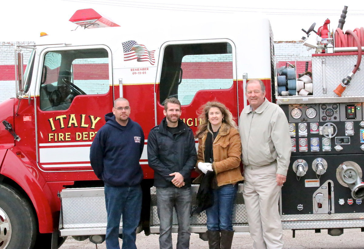 Image: Italy Fire Department lieutenant Brad Chambers, Veteran Navy Seal and parade grand marshall, Ryan “Birdman” Parrott,  city employee Rhonda Cockerham and City of Italy Mayor James Hobbs pose next to an Italy Fire Truck after Parrott received the key to the city from the Mayor.