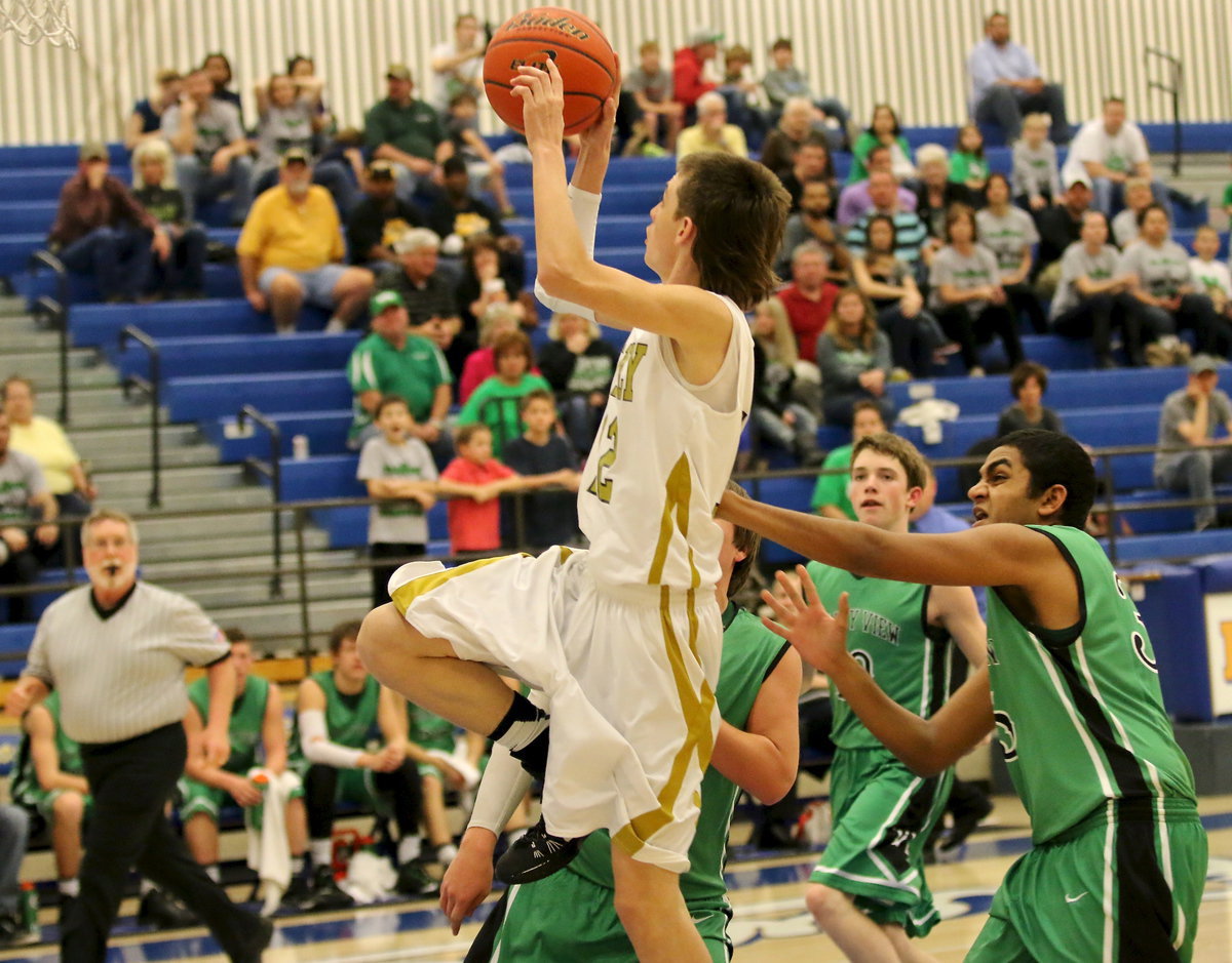 Image: Gladiator Ty Windham(12) is shoved hard from behind while shooting.