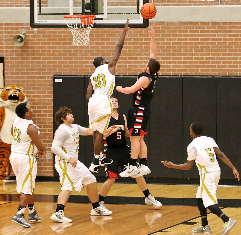 Image: TaMarcus Sheppard(10) gets high to defend the basket with teammates Darol Mayberry(13), Kevin Roldan(33) and Kevin Johnson(5) ready to rebound a miss.