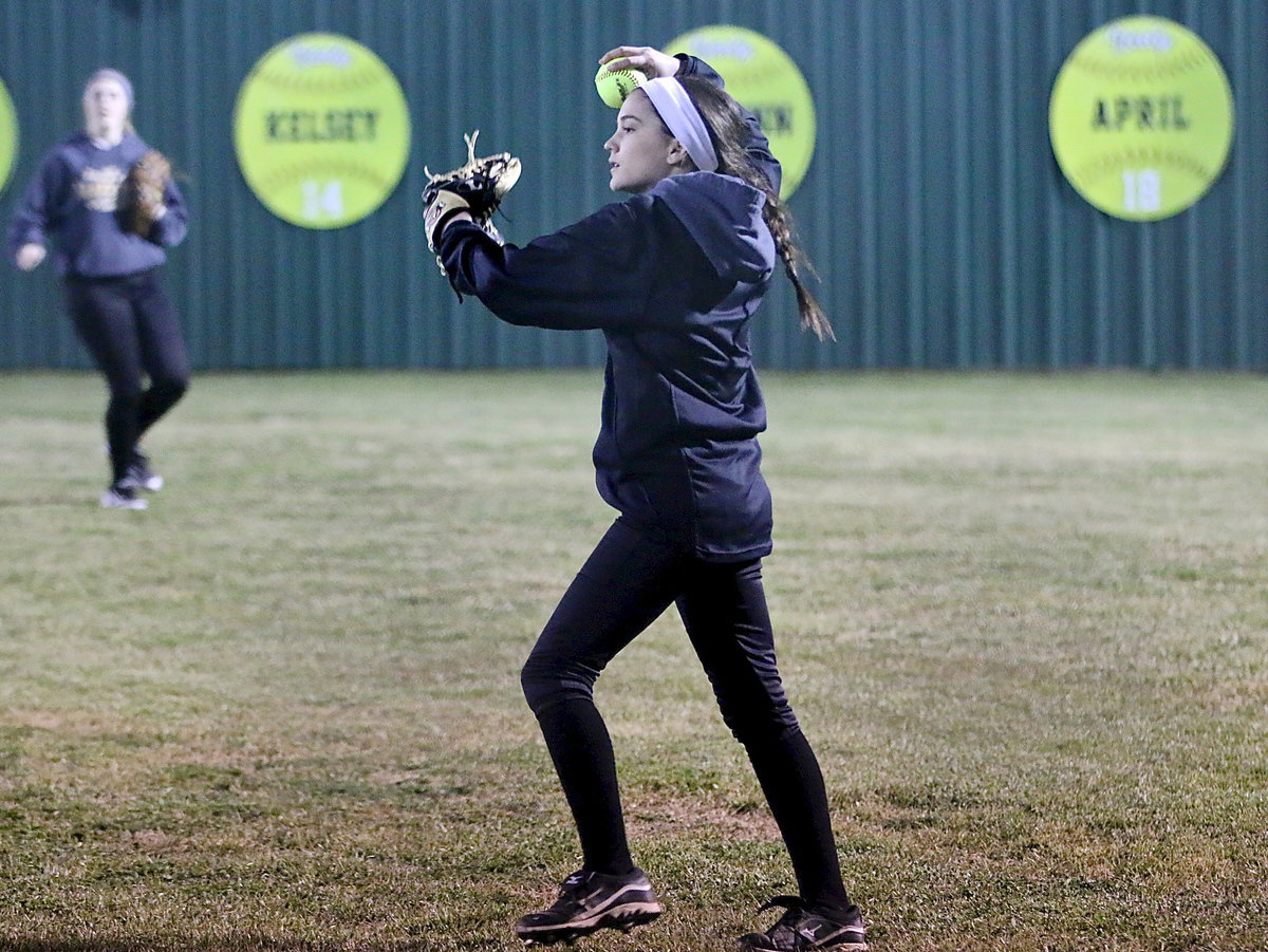 Image: Italy’s Cassidy Childers fields a grounder and then throws it in from right field.