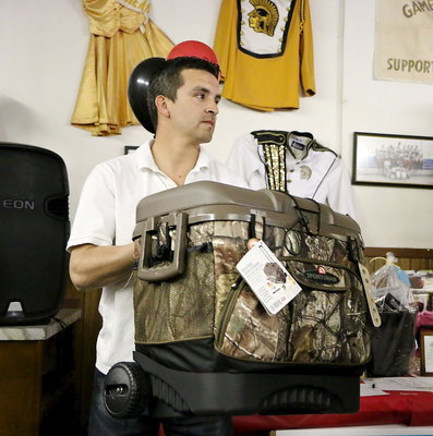 Image: School Board member Sal Ramirez displays a hot item for auction.