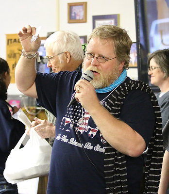 Image: Assistant band director David Graves models lady scarves and jewelry during the auction, but not because he has to.