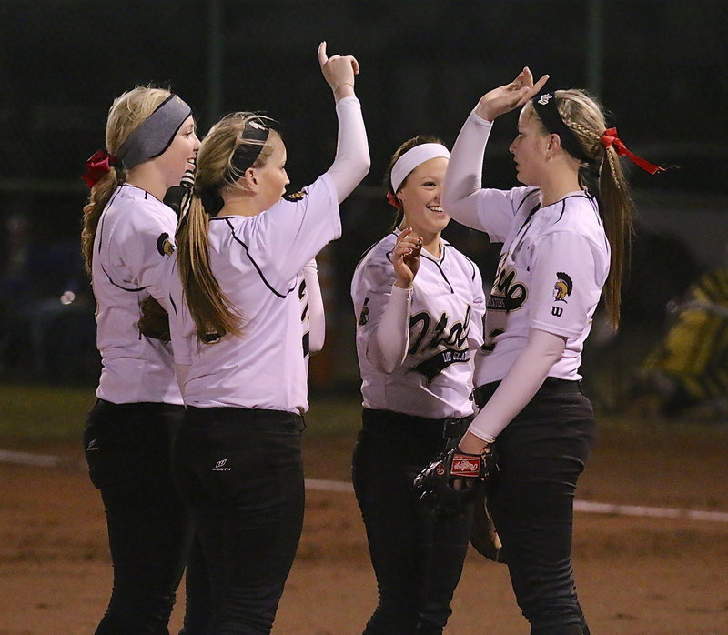 Image: Jaclynn Lewis(15), Hannah Washington(6), Bailey Eubank(1) and Tara Wallis(5), who is in their somewhere, huddle with pitcher Madison Washington(2) to start an inning.