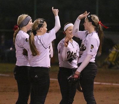 Image: Jaclynn Lewis(15), Hannah Washington(6), Bailey Eubank(1) and Tara Wallis(5), who is in their somewhere, huddle with pitcher Madison Washington(2) to start an inning.