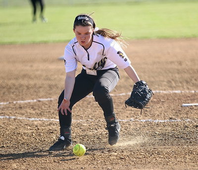 Image: Italy pitcher Tara Wallis(5) fields a grounder and then throws to first-base for the out.