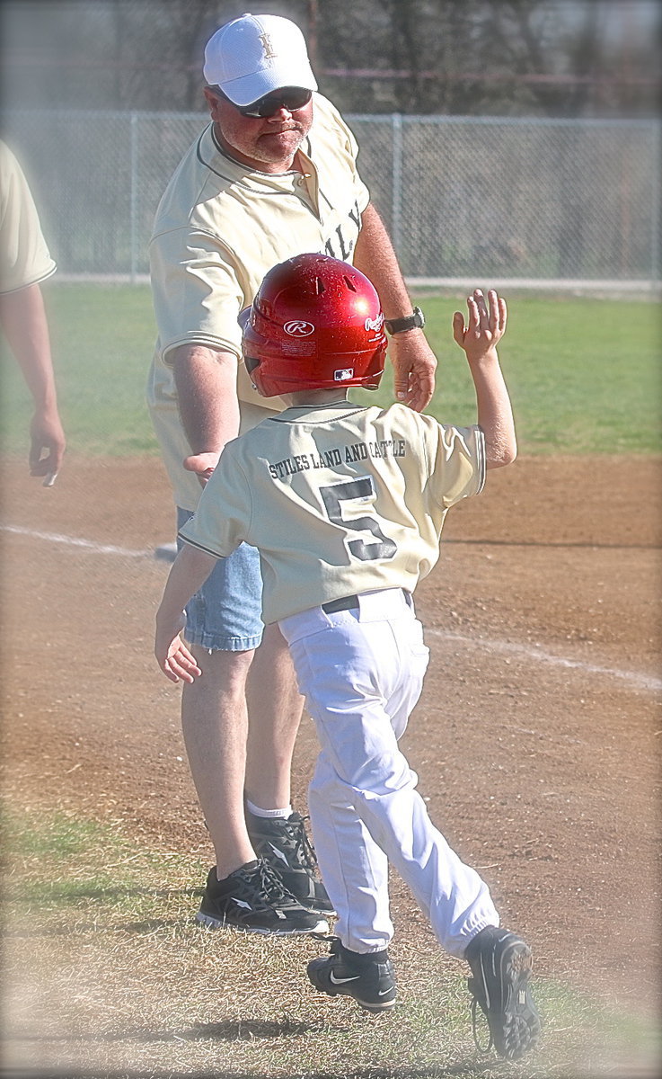 Image: Making memories — Coach Jackie Cate congratulates his son Austin Cate after Austin’s inside-the-park homerun helped seal the deal against Kopperl.